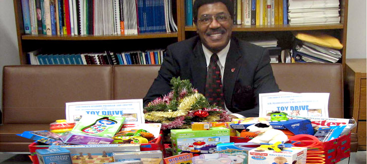 Assemblyman William Scarborough, Honorary Chair of the Millions Fathers Club, gathers toys collected by the Children's Studies Program and Center.