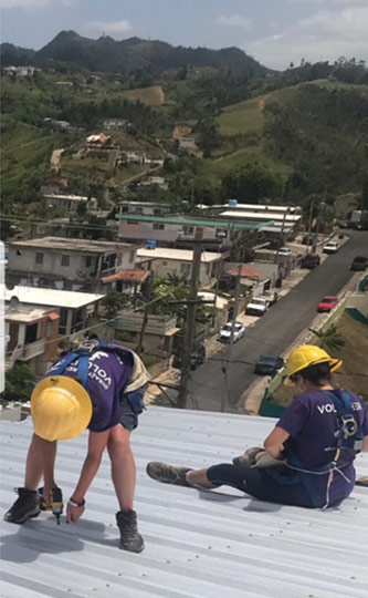 Eliana Green and another CUNY Service Corps member repairing a homeowner's roof in Puerto Rico.