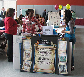 Members of Children First Club staff a table at a Brooklyn College Open House.