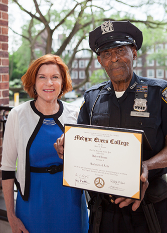 Officer Hubert Evans sharing his degree with President Karen L. Gould. 