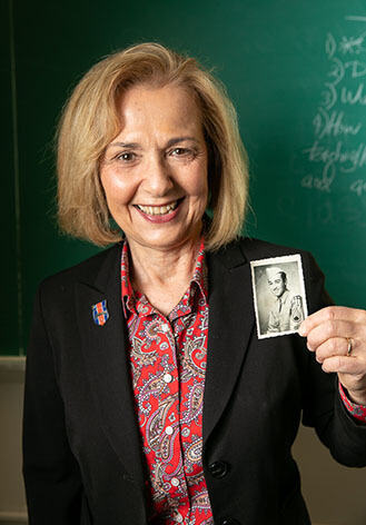 Janice Pumelia, adjunct professor of secondary education at Brooklyn College shows a photo of her father Anthony Pumelia, an <em>HMT Rohna</em> survivor.